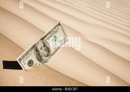 100 Dollarschein in sand Stockfoto