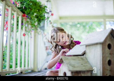 Junges Mädchen malen ein Vogelhäuschen Stockfoto