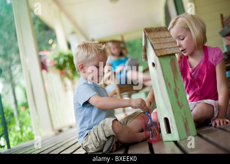 Bruder und Schwester Malerei Vogelhaus zusammen Stockfoto