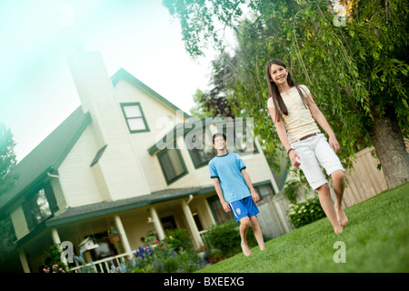 Bruder und Schwester zu Fuß auf Rasen Stockfoto