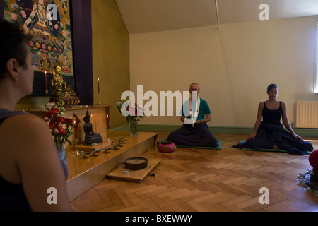 Buddhisten meditieren schweigend für 30 Minuten in den Altarraum in Bruchtal buddhistischen Retreat Centre, England. Stockfoto