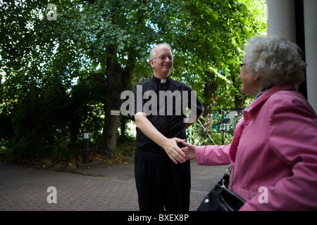 Katholischer Priester Gebote verabschieden Pfarrkind nach der Frühmesse am St.-Laurentius Kirche in Feltham, London. Stockfoto