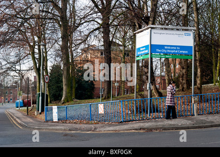 Eine Frau stand außerhalb Nottingham City Krankenhaus Rauchen einer Zigarette Stockfoto