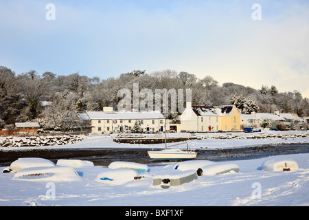 Dorf Schnee Szene mit umgedrehten Boote an der Küste in Aonb im Winter Dezember 2010. Red Wharf Bay (Traeth Coch) ISLE OF ANGLESEY Wales England Großbritannien Stockfoto