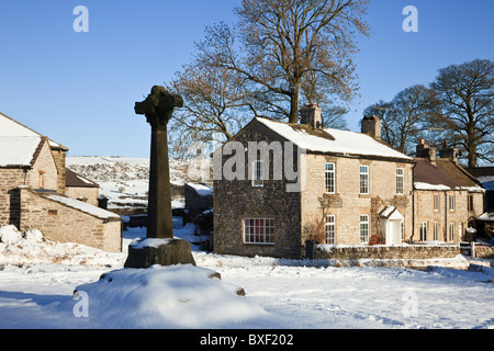 14. Jahrhundert steinerne Kreuz in der dovedale Village Green mit Schnee im Winter 2010. Foolow, Derbyshire, England, Großbritannien, Großbritannien. Stockfoto