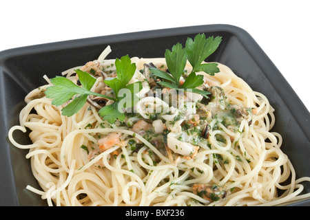 Spaghetti mit Garnelen, Tintenfische, Muscheln und Petersilie isoliert auf weiss Stockfoto