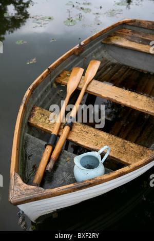 Eine alte verwitterte Holz Ruderboot mit Ruder und Wasserkrug, Ansicht von oben. Stockfoto