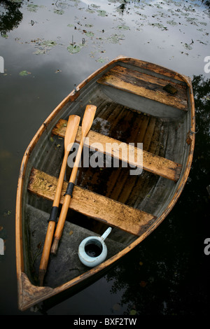 Eine alte verwitterte Holz Ruderboot mit Ruder und Wasserkrug, Ansicht von oben. Stockfoto