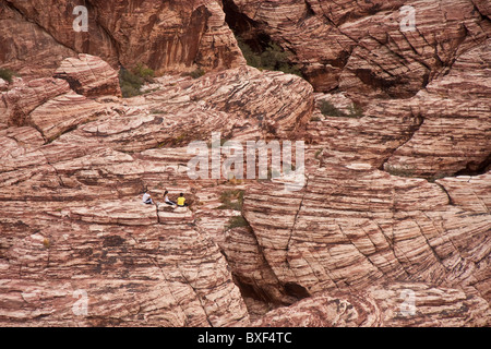 Wanderer ruht auf einem flachen Felsen im Red Rock Canyon, Nevada Stockfoto