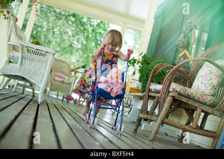 Kleines Mädchen Puppe in Kinderwagen schieben Stockfoto