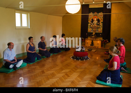 Buddhisten meditieren schweigend für 30 Minuten in den Altarraum in Bruchtal buddhistischen Retreat Centre, England. Stockfoto