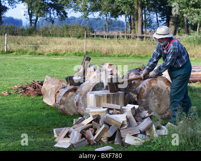 Mann, Spalten Brennholz mit einer Axt. Stockfoto