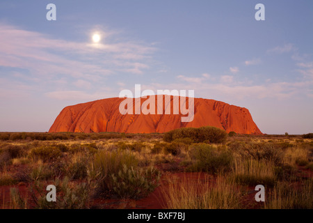 Dämmerung mit dem Vollmond steigt über Uluru (Ayers Rock), Uluru-Kata Tjuta National Park, Yulara, Northern Territory Stockfoto