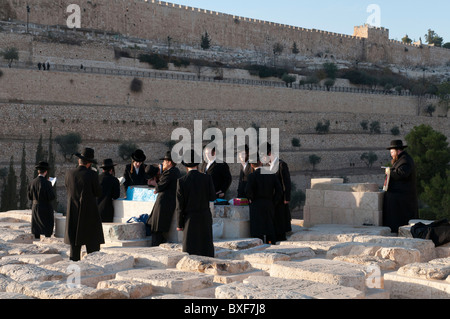 Gruppe von orthodoxen Juden beten um ein Grab am Ölberg Stockfoto