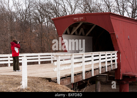 Immer noch ziehen die wenigen restlichen gedeckten Brücken von Madison County, Iowa Touristen. Hier fotografiert ein Tourist der Hogback Brücke Stockfoto