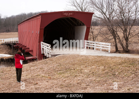 Immer noch ziehen die wenigen restlichen gedeckten Brücken von Madison County, Iowa Touristen. Hier fotografiert ein Tourist der Hogback Brücke Stockfoto
