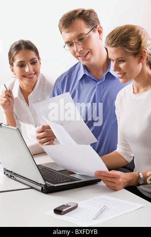 Team von drei Geschäftsleute, die in den Papieren im Büro Stockfoto