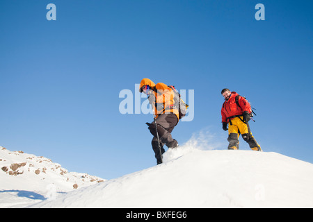 Kletterer bei starkem Wind, Schnee oberhalb Grasmere im Lake District, UK Umzug von Spindrift gestrahlt wird. Stockfoto