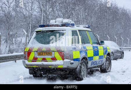 PSNI Polizei Geländewagen 4 x 4 nicht mehr auf Autobahn neben stecken Fahrzeug an einem kalten schneereichen Wintertag Belfast Nordirland Stockfoto