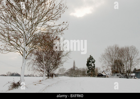 Eine kleine Farm liegt unter einem senkende Himmel mit Schnee auf dem Boden Stockfoto