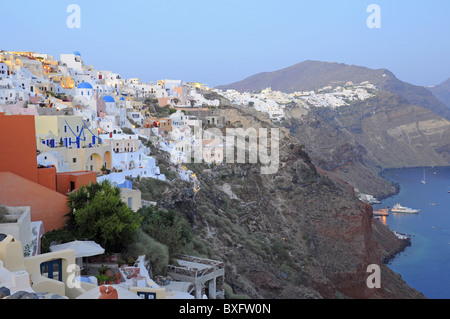 Weiß getünchte Häuser auf der Klippe. Hafen mit der Fähre im Dorf Oia, Santorin Stockfoto