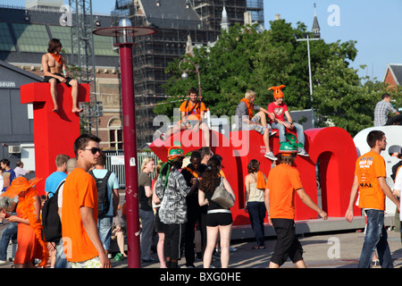 Fußballfans gehen auf dem Museumplein, Amsterdam, in Erwartung des WM-Finales zwischen den Niederlanden und Spanien 2010 Stockfoto