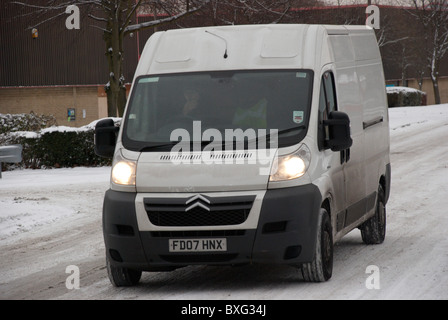 weißer Lieferwagen auf einer eisglatten Straße Stockfoto