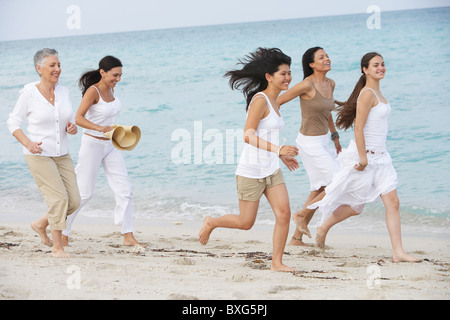 Diverse Frauen zusammen am Strand laufen Stockfoto