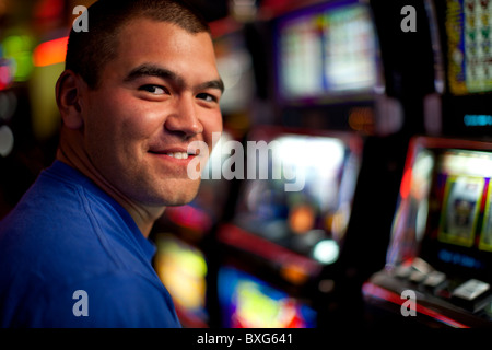 Gebürtige amerikanische Mann spielen Spielautomaten im casino Stockfoto