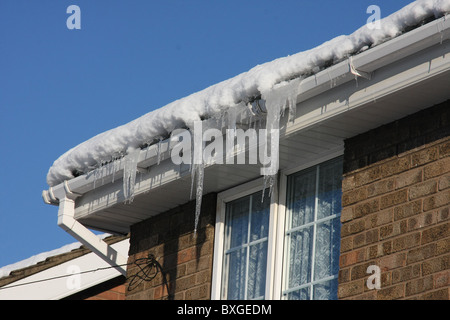 Eiszapfen hängen von inländischen Haus Dachrinne bei extrem kaltem Wetter. Stockfoto