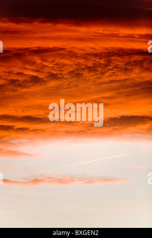 Dramatische Wolken / cloud / bewölkt Red sky bei Sonnenuntergang / Nacht mit Jet Flugzeug Dampf Trail über Heathrow Flughafen, West London. Stockfoto
