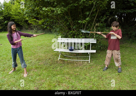 Zwei Freunde spielen gegeneinander kämpfen mit Bambus Wasserpistolen. Stockfoto