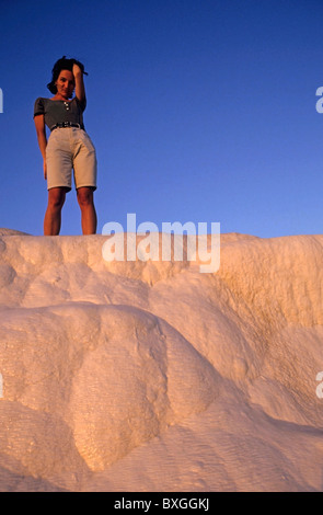 Junge Frau aufstehen auf weißen Felsen bei Sonnenuntergang. Stockfoto