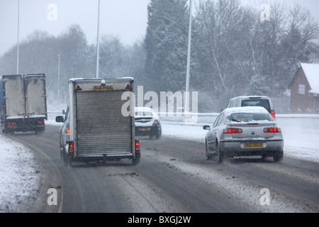 Auto Transporter und Anhänger auf einer zusammengebissenen Autobahn an einem kalten verschneiten Winter Tag Belfast Nordirland Stockfoto