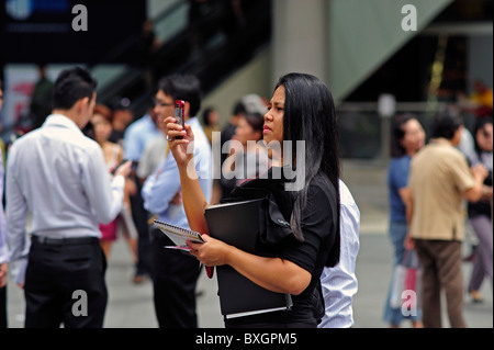 Singaporean business lady texting fotografieren Raffles Place Singapore Stockfoto