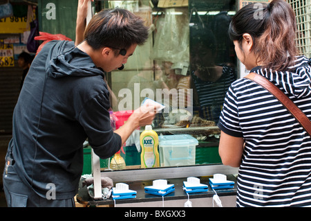 Verkäufer demonstriert seine Fensterreinigungs-Produkt bei der Ladies' Market, Mongkok, Kowloon, Hong Kong, China Stockfoto