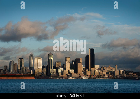 Die Aussicht auf die Skyline von Seattle, Washington, über Elliott Bay mit einem Containerschiff im Hafen von Seattle zu laden warten. Stockfoto