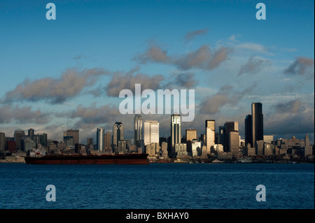 Die Aussicht auf die Skyline von Seattle, Washington, über Elliott Bay mit einem Containerschiff im Hafen von Seattle zu laden warten. Stockfoto