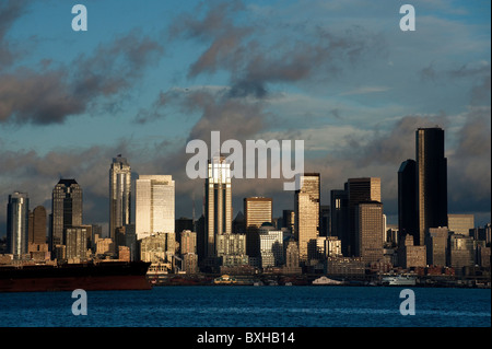 Die Aussicht auf die Skyline von Seattle, Washington, über Elliott Bay mit einem Containerschiff im Hafen von Seattle zu laden warten. Stockfoto