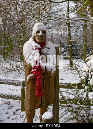 Eine hölzerne Skulptur mit Schnee in Thorndon Park in Essex bedeckt.  Foto von Gordon Scammell Stockfoto