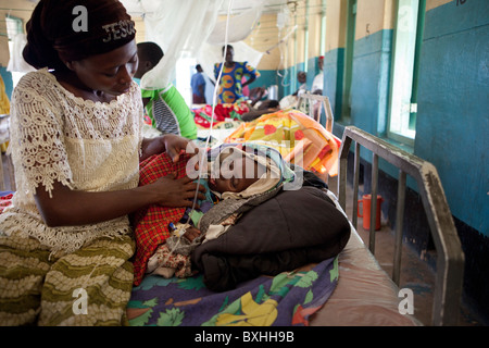 Eine Frau kümmert sich um ihre Tochter sterben an AIDS in Amuria, Uganda, Ostafrika. Stockfoto