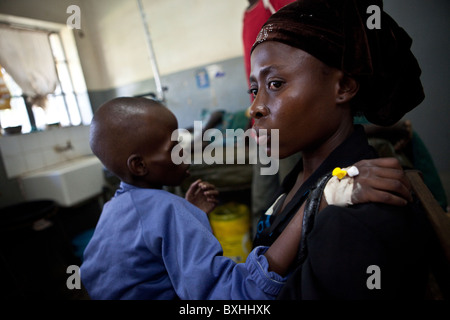 Eine Mutter bringt ihr Kind zu einem AIDS-Behandlung-Center in Soroti, Uganda, Ostafrika. Stockfoto