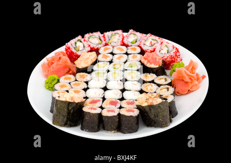 viele Sushi Rollen auf einem großen Teller, isoliert auf schwarz, Schneidepfad Stockfoto