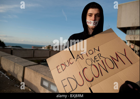 Aberystwyth Studenten besuchten einen Flashmob außerhalb Aberystwyth Arts Centre im Hintergrund halten Plakate mit den Mund mit Klebeband schließen Stockfoto