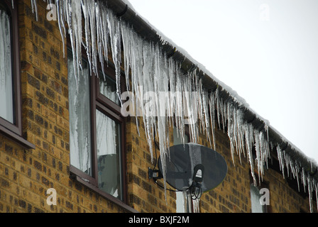 Es gibt viele große Eiszapfen hängen von einer Dachrinne. UK, Dezember 2010. Stockfoto