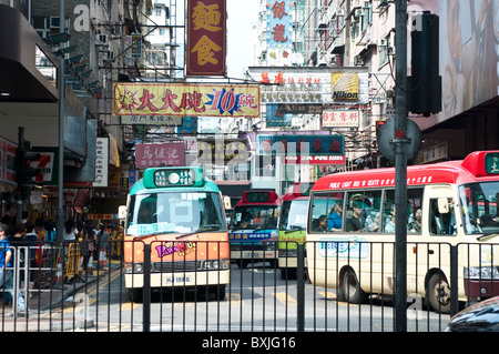 Belebte Straße mit leichten Linienbusse und Werbeschilder, Mong Kok, Cowloon, Hong Kong, China Stockfoto