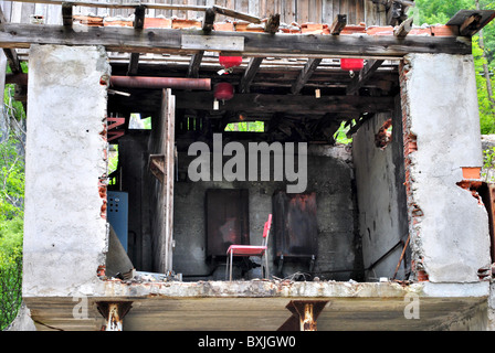 verlassene Haus und zerstörte mit einem Stuhl im Raum ohne Wände Stockfoto