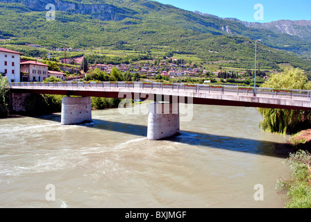 Etsch-Mündung mit frischem Wasser in Trentino Alto Adige und Hintergrund Wald und Wohnhäuser Stockfoto