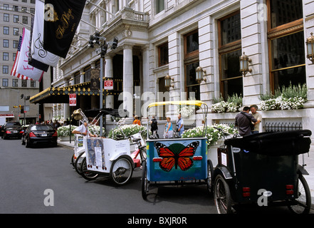 Eingang zum Plaza Hotel in New York City mit Pedikünen, die in der Straße geparkt sind. Eine Touristenattraktion für einfache Besichtigungstouren im Central Park. USA Stockfoto