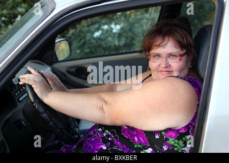 übergewichtige Frau hinter dem Steuer des Autos sitzen Stockfoto